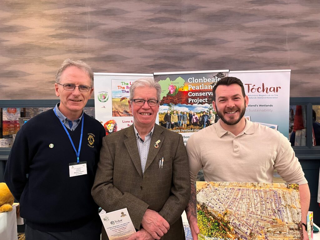 Lions Club and Brian Gorman holding an aerial photograph of the peat dams installed on Clonbeale More Bog